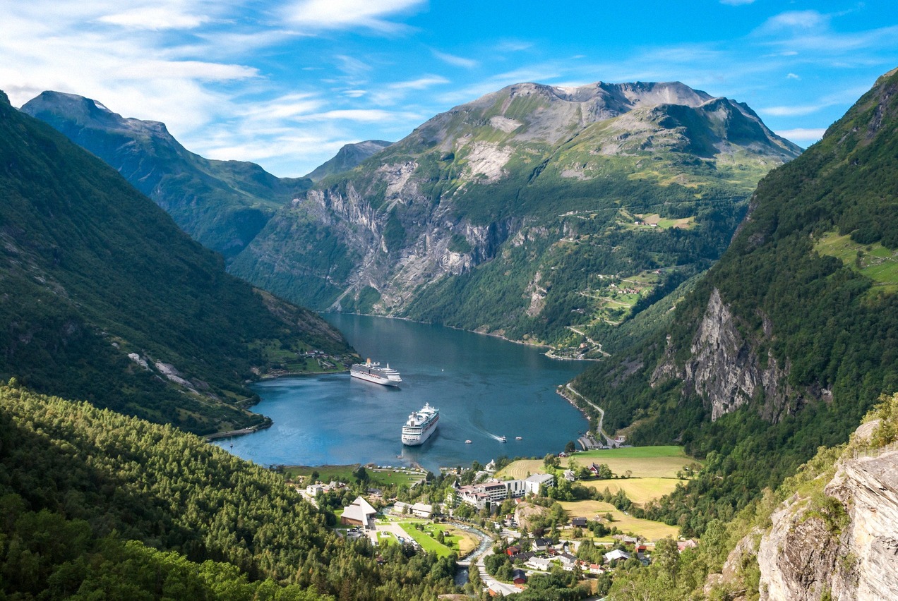 Der Geirangerfjord von oben mit zwei Kreuzfahrtschiffen vor dem Dorf Geiranger
